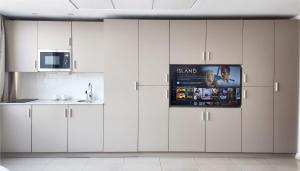 a kitchen with white cabinets and a poster on the wall at Résidences Plein Ciel in Abidjan