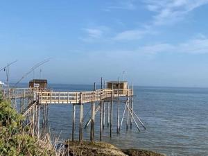 een pier op de oceaan met een blauwe lucht bij Appartement à Royan avec accès piscine in Royan