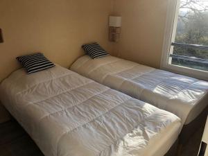twee bedden naast een raam in een kamer bij Appartement à Royan avec accès piscine in Royan