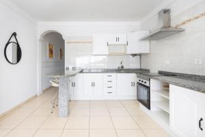 une cuisine avec des armoires blanches et un comptoir en marbre dans l'établissement Tranquilidad, playa y vistas al mar, à Callao Salvaje 18 autres photos