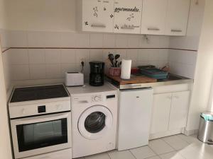 een keuken met een fornuis en een wasmachine bij Appartement à Royan avec accès piscine in Royan
