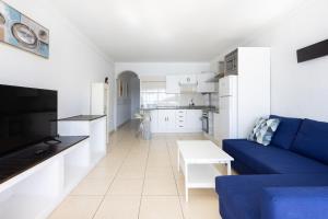 un salon avec un canapé bleu et une cuisine dans l'établissement Tranquilidad, playa y vistas al mar, à Callao Salvaje