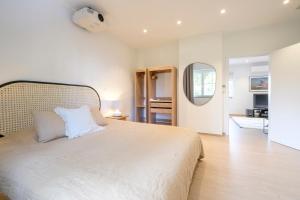 - une chambre avec un grand lit blanc et un miroir dans l'établissement Appartement cocooning 1 chambre proximité Golf Waterloo à Lasnes, à Lasne
