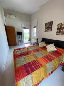 Shambala B&B في سيتجيس: غرفة نوم مع سرير كبير مع بطانية ملونة
