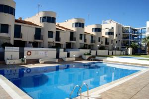 a swimming pool in front of a building at REGIA BAHIA - Cabo Roig - SEA VIEW in Playas de Orihuela