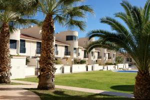 two palm trees in front of a building at REGIA BAHIA - Cabo Roig - SEA VIEW in Playas de Orihuela