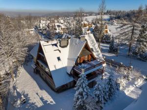 una vista aérea de una casa cubierta de nieve en RentPlanet - Śpiący Rycerz, en Zakopane