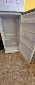 einem leeren Kühlschrank mit offener Tür in der Küche in der Unterkunft Cabaña Don Justino in El Calafate