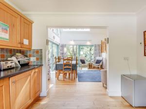 a kitchen and living room with a table and chairs at Ptarmigan Cottage-ukc5518 in Boat of Garten