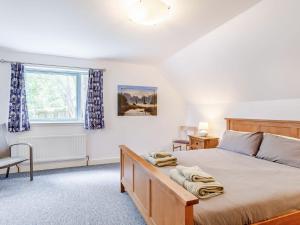 una camera con un grande letto e una finestra di Ptarmigan Cottage-ukc5518 a Boat of Garten