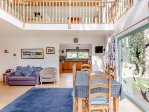 a living room with a table and chairs and a staircase at Ptarmigan Cottage-ukc5518 in Boat of Garten