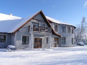 a house with snow on the ground in front of it at Gosciniec Wydminy in Wydminy