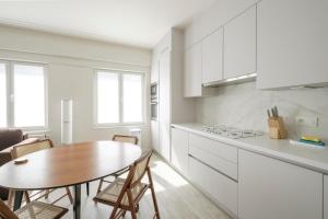 cocina con mesa de madera y comedor en Bel appartement épuré 2 chambres Brugmann, en Bruselas