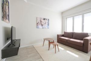 sala de estar con sofá y mesa en Bel appartement épuré 2 chambres Brugmann, en Bruselas