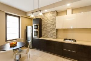 a kitchen with a table and a refrigerator at Central Cosy 5BD-5BATH Apartment in Tbilisi City