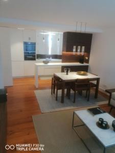 a living room with a table and a kitchen at Timeless - Energy - Belém in Lisbon