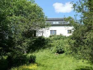 una casa blanca en medio de unos árboles en The Byre - by Where Stags Roar, en Newtonmore 19 fotos más