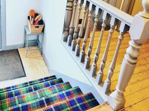 Una escalera con una alfombra al lado de una escalera. en Caman House Apt 2 - by Where Stags Roar, en Newtonmore