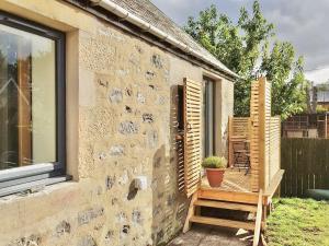 een stenen huis met een raam en een bank bij The Bakehouse - by Where Stags Roar in Newtonmore