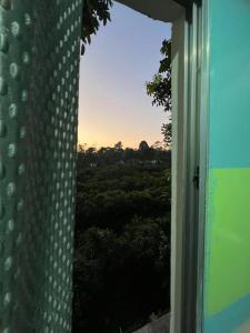 an open window with a view of a forest at The PugMark Wildlife Resort in Jyoti Gaon