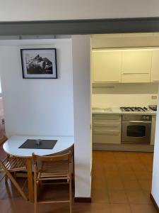 a kitchen with a white table and a table and chairs at vicolo forno in Mercallo