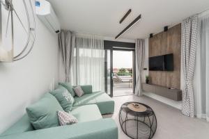 - un salon avec un canapé vert et une télévision dans l'établissement Luxury Villas Joy, à Novalja