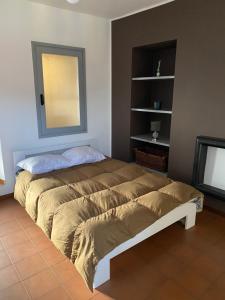 a bedroom with a bed with a mirror and a television at vicolo forno in Mercallo