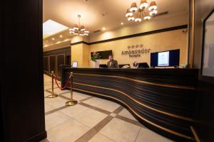a man sitting at a reception desk in a hotel lobby at Hotel Ambasador in Bucharest