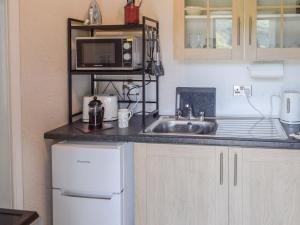 una cucina con lavandino e forno a microonde di The Old Croft House a Strontian