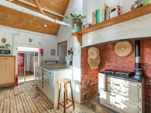 a kitchen with a brick wall and a stove at Sheepwash Square House in Sheepwash