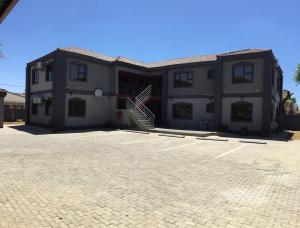 a building with a parking lot in front of it at Sekaka Fully Furnished Apartments in Gaborone