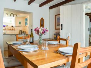 a dining room table with plates and a vase of flowers at Trevivian House in Boscastle