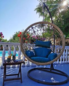 uma cadeira de vime com almofadas azuis num alpendre em Holiday home Iva with pool em Sukošan
