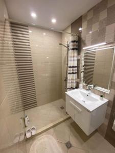 a bathroom with a white sink and a mirror at Gardenia Apartment in Veliko Tŭrnovo