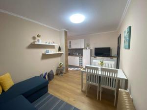sala de estar con sofá azul y cocina en Gardenia Apartment, en Veliko Tŭrnovo