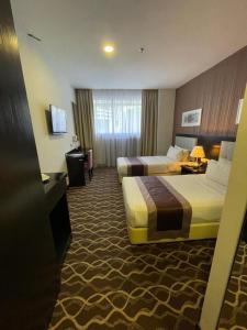 a hotel room with two beds and a television at The Grand Campbell Hotel Kuala Lumpur in Kuala Lumpur