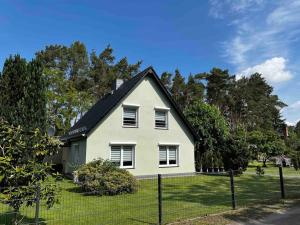 una casa blanca con techo negro en -Haus am Wäldchen-, en Zehdenick