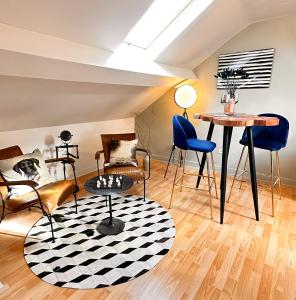 sala de estar con sillas, mesa y alfombra en Appartements design - Uniques - Centre, en Bagnères-de-Bigorre