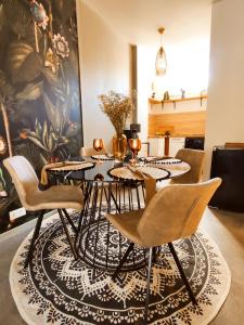 un comedor con mesa y sillas sobre una alfombra en Appartements design - Uniques - Centre, en Bagnères-de-Bigorre