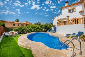 a backyard with a swimming pool and a house at Villa Serena - PlusHolidays in Calpe