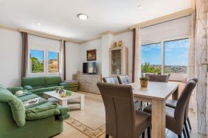 a living room with a green couch and a table at Villa Serena - PlusHolidays in Calpe