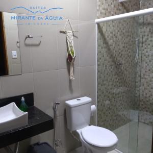 La salle de bains est pourvue de toilettes, d'un lavabo et d'une douche. dans l'établissement Suítes Mirante da Águia, à Ibicoara