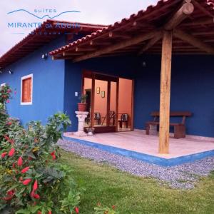 a blue house with a bench on a patio at Suítes Mirante da Águia in Ibicoara