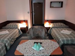 ein Hotelzimmer mit 2 Betten und einem Tisch in der Mitte in der Unterkunft Penzion Agrothermal in Bešeňová