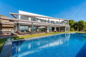 una casa grande con piscina frente a ella en Villa Campomanes - PlusHolidays, en Altea