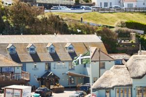 a group of buildings with cars parked in a parking lot at Hope & Anchor in Hope Cove