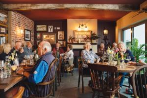 a group of people sitting at tables in a restaurant at Hope & Anchor in Hope Cove