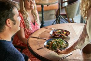 a group of people sitting at a table with a plate of food at Hope & Anchor in Hope Cove