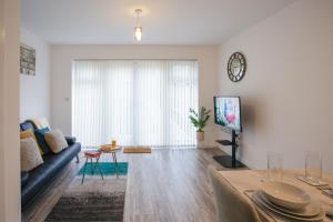a living room with a couch and a tv at Cosy 2-bed home - For Company contractor and Leisure stays - NEC, Airport, HS2, Contractors, Resort World in Marston Green