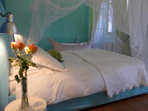1 dormitorio con 1 cama con un jarrón de flores sobre una mesa en B&B Casa Fenoglio en Ventimiglia